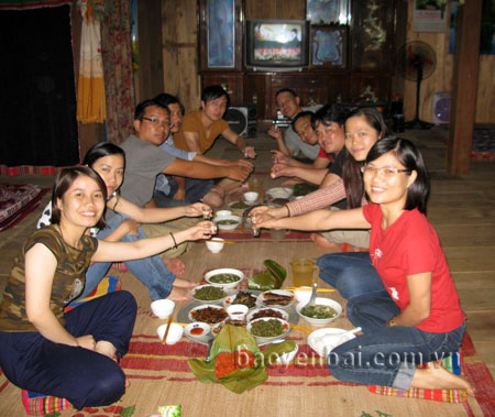 Khách du lịch thưởng thức ẩm thực ngay tại ngôi nhà sàn đón khách của chị Lường Thị Hồng Chung.
