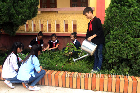 Các em học sinh chăm sóc vườn hoa trong khuôn viên của trường.