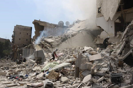 Nhân viên cứu hộ Syria tìm kiếm nạn nhân dưới những đống đổ nát sau vụ không kích tại Aleppo.