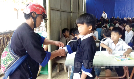 Anh Hờ A Cu ở bản Tủa Mả Pang, xã Khao Mang, huyện Mù Cang Chải đưa con tới trường.
