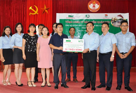 Đồng chí Nguyễn Quang Hiện - Tổng Giám Công ty Cổ phần Bảo hiểm Quân đội (MIC) trao kinh phí hỗ trợ nhân dân huyện Mù Cang Chải cho lãnh đạo Uỷ ban MTTQ tỉnh.