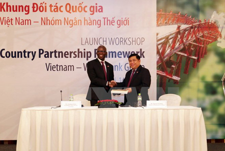Giám đốc Quốc gia WB tại Việt Nam Ousmane Dione trao sách công bố Khung đối tác Quốc gia cho Bộ trưởng Bộ Kế hoạch và Đầu tư Nguyễn Chí Dũng.