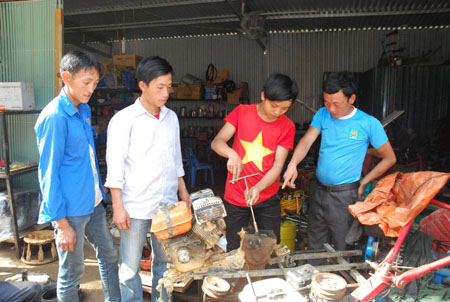 Anh Vàng A Chư (bên phải) dạy nghề sửa chữa máy nông cụ cho thanh niên các xã trong và ngoài huyện.