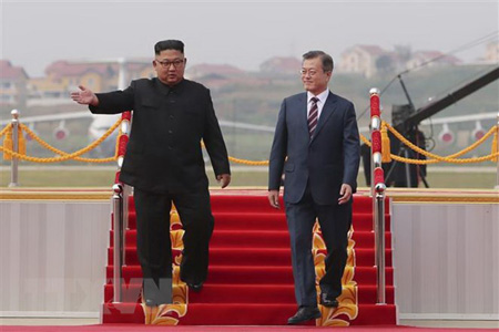Nhà lãnh đạo Triều Tiên Kim Jong-un (trái) đón Tổng thống Hàn Quốc Moon Jae-in (phải) ở sân bay quốc tế Bình Nhưỡng ngày 18/9.