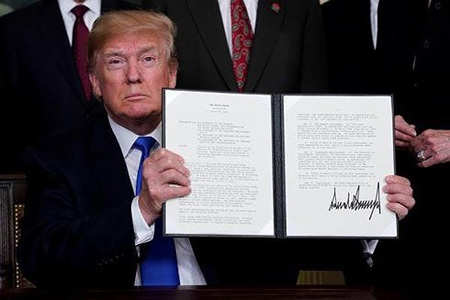 Tổng thống Donald Trump cầm văn bản ghi nhớ về việc áp thuế hàng hóa của Trung Quốc tại Nhà Trắng hôm 22/3.