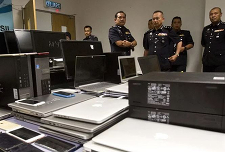 Những chiếc điện thoại, laptop bị tịch thu trong vụ truy quét mới nhất của cảnh sát Malaysia.