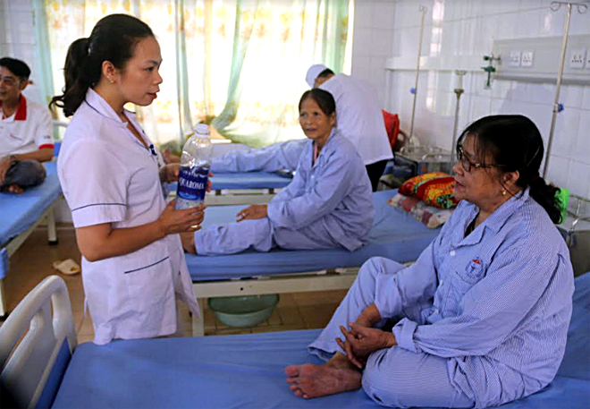 Cán bộ Trung tâm y tế huyện Yên Bình tuyên truyền đến bệnh nhân và người nhà cùng chung tay giảm thiểu chất thải nhựa, túi nilon khó phân hủy trong sinh hoạt.