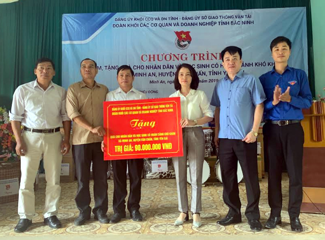 Đoàn công tác trao biển tượng trưng phần quà trị giá 90 triệu đồng cho lãnh đạo xã Minh An, huyện Văn Chấn.