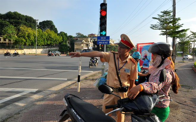 Lực lượng cảnh sát giao thông hướng dẫn, tuyên truyền người tham gia giao thông tại ngã tư Km5, thành phố Yên Bái.
