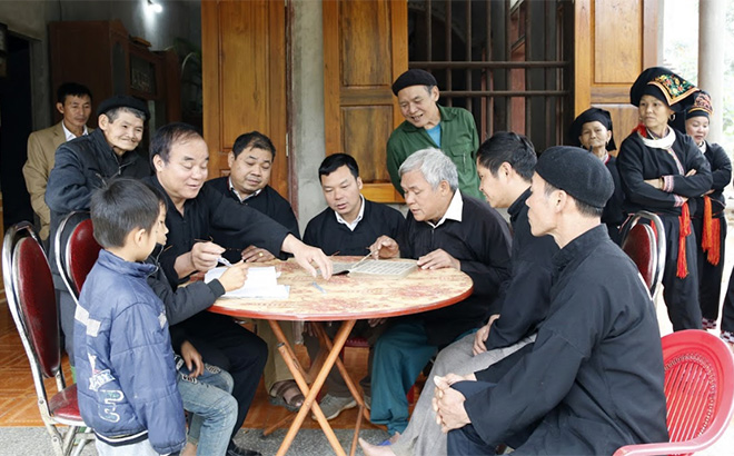 Ông Bàn Văn Kim hướng dẫn người dân và thế hệ trẻ trong thôn học chữ viết của người Dao.