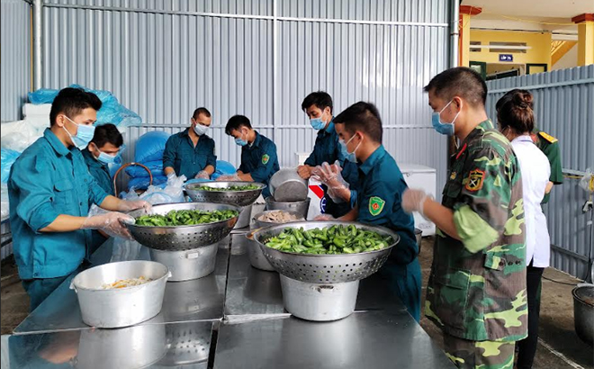 Các chiến sĩ dân quân chuẩn bị bữa ăn trong Khu cách ly Trường Phổ thông Dân tộc nội trú Trấn Yên.
