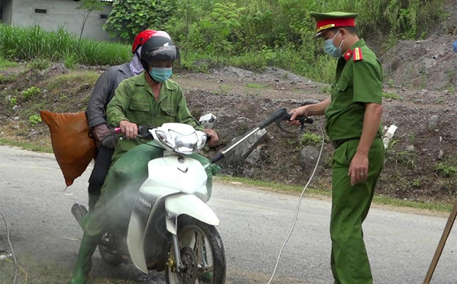 Lực lượng chức năng tại Chốt kiểm dịch đèo Lũng Lô phun khử khuẩn phương tiện qua chốt.