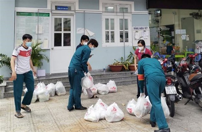 Lực lượng tại địa phương tiếp nhận và tổ chức phân phối đơn hàng đi chợ hộ đến người dân.