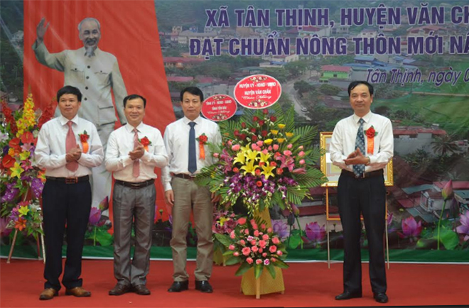 Lãnh đạo huyện Văn Chấn tặng hoa chúc mừng xã Tân Thịnh - xã đầu tiên của huyện đạt chuẩn nông thôn mới nâng cao.