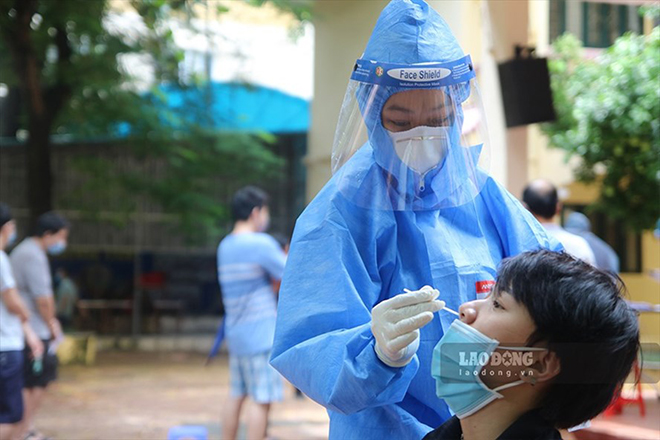 Nhân viên y tế lấy mẫu xét nghiệm cho người dân tại phường Láng Thượng (quận Đống Đa, Hà Nội).