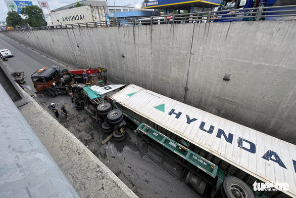 Container lật ngang chắn gần hết hầm chui khiến giao thông qua đây bị gián đoạn.