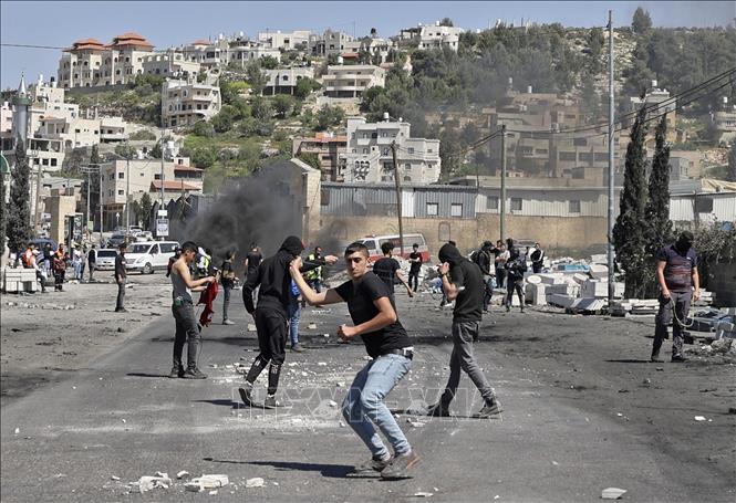 Người biểu tình Palestine ném đá về phía cảnh sát Israel trong cuộc đụng độ tại khu vực Đền Al-Aqsa ở Đông Jerusalem ngày 15/4/2022.