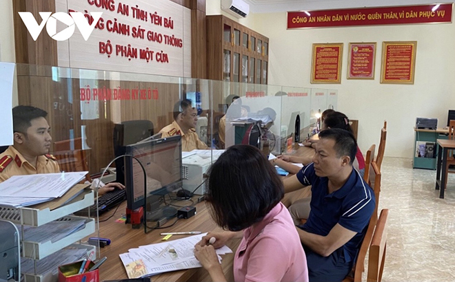 Người dân đến làm thủ tục được cán bộ, chiến sỹ Phòng CSGT, Công an tỉnh Yên Bái hướng dẫn tận tình