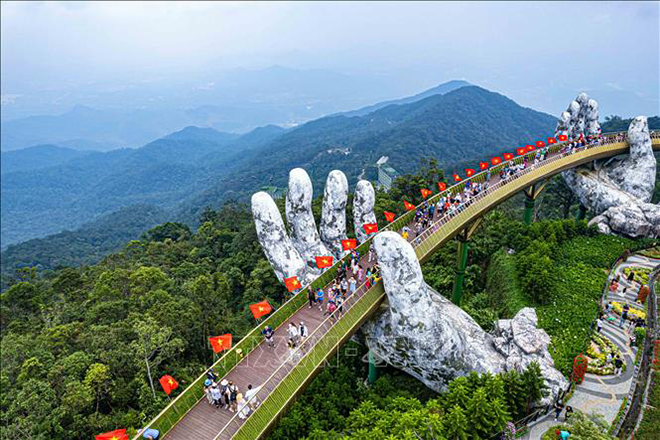 Đón lễ Quốc khánh năm nay， Khu du lịch Sun World Ba Na Hills trang trí 100 lá cờ đỏ， sao vàng dọc thành Cầu Vàng với tổng chiều dài 148，6m.