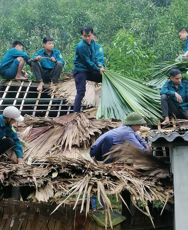 Cán bộ, chiến sĩ lực lượng vũ trang huyện Lục Yên giúp dân lợp lại mái nhà tại xã An Lạc.