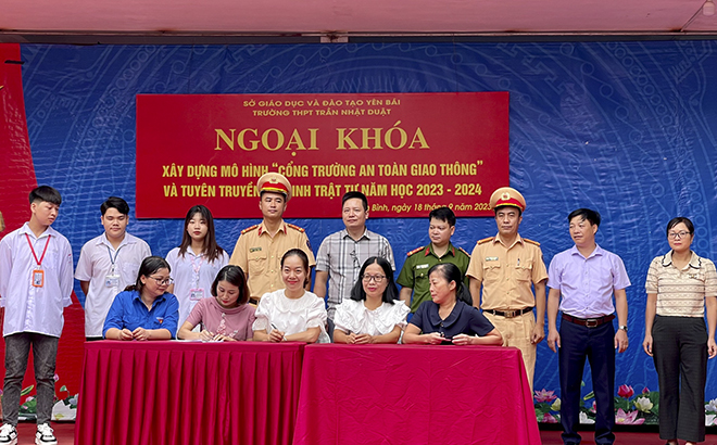 Giáo viên, học sinh Trường THPT Trần Nhật Duật ký cam kết chấp hành nghiêm pháp luật về giao thông tại chương trình ngoại khóa triển khai xây dựng mô hình “Cổng trường an toàn giao thông”.