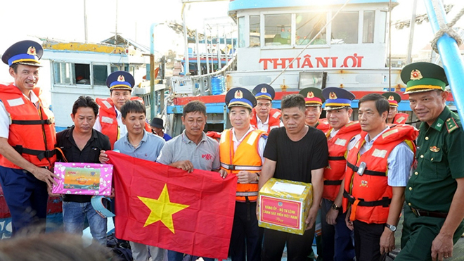 Trung tướng Bùi Quốc Oai động viên, tặng quà và cờ Tổ quốc cho ngư dân tại cảng cá Phú Quý.