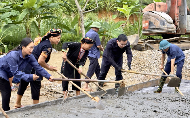 Lãnh đạo huyện Yên Bình tham gia đổ bê tông và đắp lề đường với bà con nhân dân thôn Quyết Thắng 2, xã Cảm Nhân.