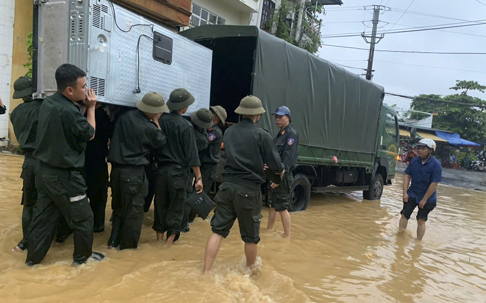 Cán bộ chiến sĩ Phòng Cảnh sát cơ động, Công an tỉnh Yên Bái giúp người dân phố Hồng Thanh, phường Hồng Hà, thành phố Yên Bái di chuyển đồ đạc đến nơi an toàn  do nước sông Hồng dâng ngập chiều nay (7/9)

