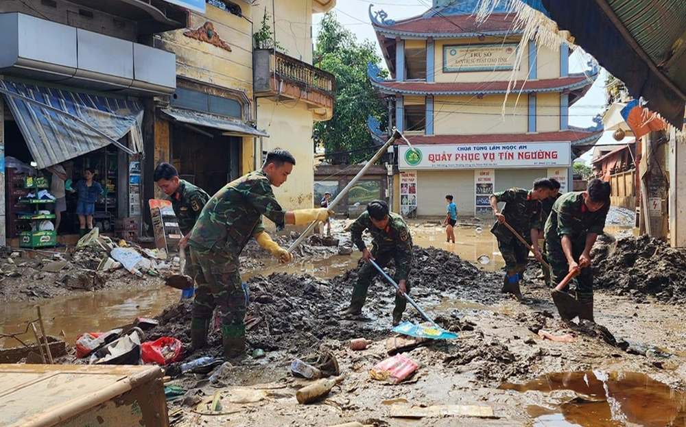 Cán bộ, chiến sĩ lực lượng vũ trang dọn dẹp, vệ sinh đường phố sau thiên tai.