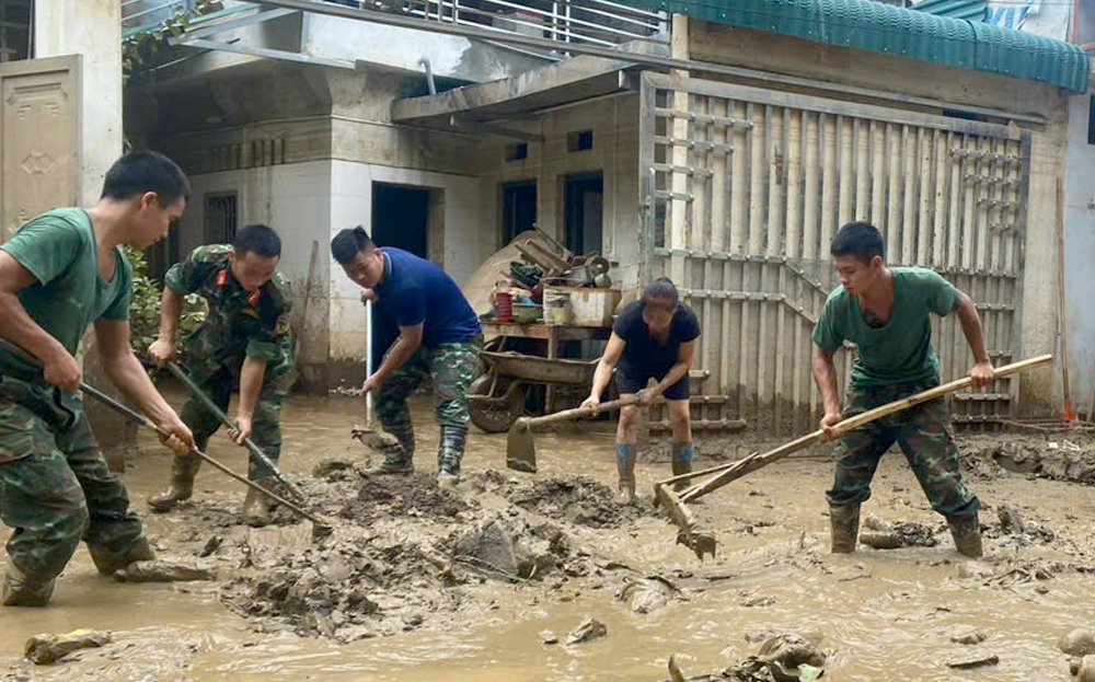 Cán bộ, chiến sĩ Quân khu 2 và Bộ Chỉ huy quân sự tỉnh cùng nhân dân tuyến đường Thanh Niên, thành phố Yên Bái dọn dẹp bùn đất, ngày 19/9.