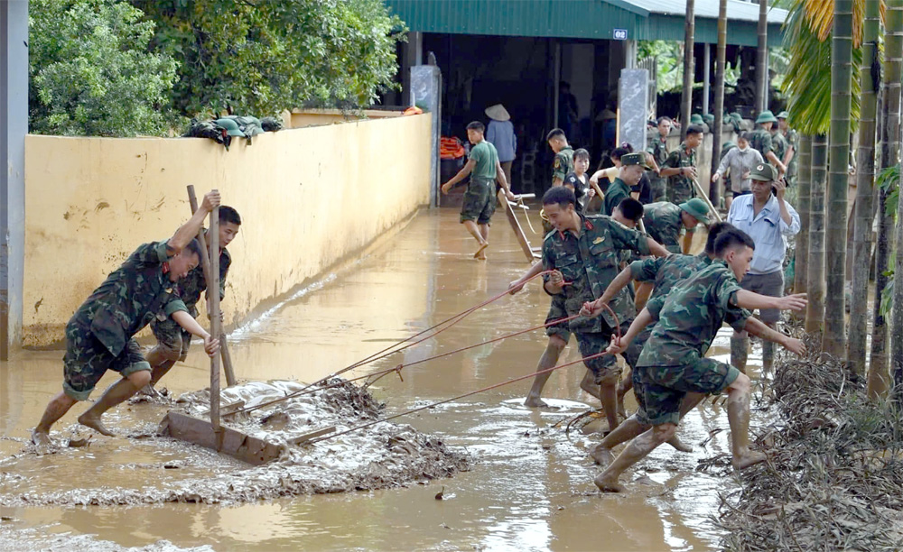 Cán bộ, chiến sĩ Trung đoàn 174 hỗ trợ nhân dân thành phố Yên Bái khắc phục hậu quả mưa lũ.
