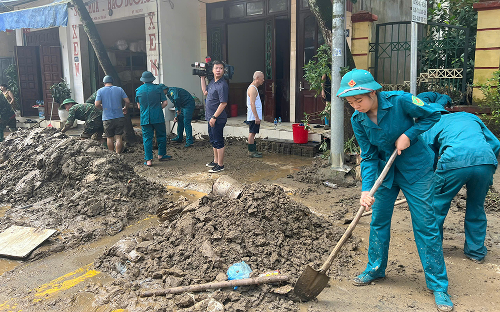 Lực lượng dân quân hỗ trợ người dân phường Hồng Hà (thành phố Yên Bái) khẩn trương dọn dẹp bùn đất sau lũ rút sáng nay -12/9.