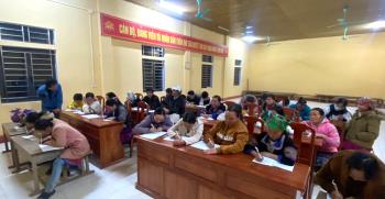 Các thầy giáo đang hướng dẫn học viên viết chữ, làm toán tại lớp xóa mù chữ ở thôn Khe Táu.