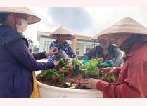 Hội viên phụ nữ phường Hợp Minh đóng góp tiền, công lao động trồng tuyến đường hoa vào cổng UBND phường.