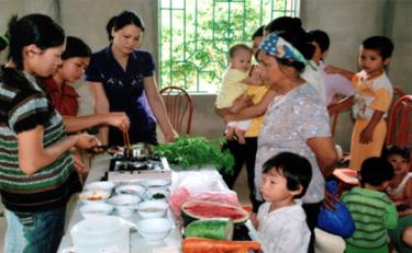 Cán bộ Trung tâm Truyền thông - Giáo dục sức khỏe tỉnh hướng dẫn chị em thực hành dinh dưỡng tại các thôn mục tiêu của chương trình phát triển vùng huyện Trấn Yên. (Ảnh: Thanh Thế)
