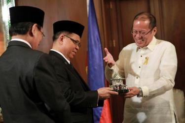 Tổng thống Philippines Benigno Aquino (phải) trao quà lưu niệm cho thủ lĩnh MILF Murad Ebrahim (giữa)