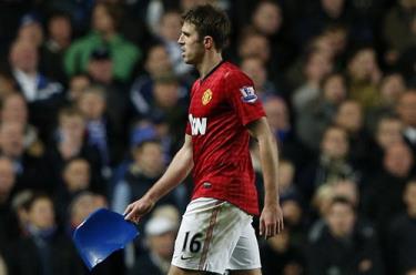 Tiền vệ Michael Carrick cầm một mảnh ghế do CĐV ném xuống sân.