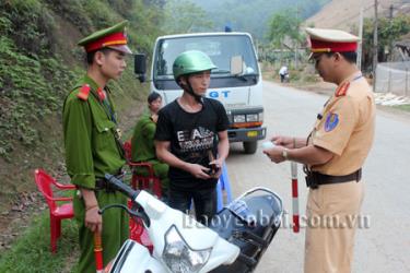 Cảnh sát giao thông huyện Văn Yên kiểm tra, nhắc nhở  người tham gia giao thông chấp hành đúng quy định về an toàn giao thông.  (Ảnh: Thạch Phong)