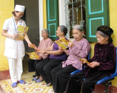 Cán bộ y tế thành phố Yên Bái phát tài liệu chăm sóc sức khỏe cho người cao tuổi phường Nam Cường.