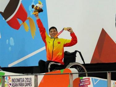 Vận động viên Võ Thanh Tùng tự hào giơ cao tấm Huy chương vàng thứ 3 tại Asian Para Games 2018.