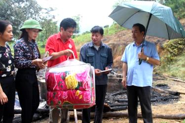 Đồng chí An Hải Nam - Phó chủ tịch UBND huyện (ngoài cùng bên phải) trao tiền hỗ trợ cho gia đình bị hỏa hoạn xã Minh Chuẩn.