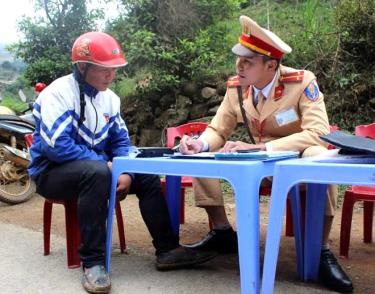 Thượng úy Lê Xuân Trường tuyên truyền pháp luật về an toàn giao thông cho người dân trong quá trình thực hiện nhiệm vụ.