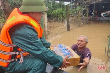 Những hộ dân đang mắc kẹt do ngập lũ nặng lội ra nhận tiếp tế lương thực, nước uống tại xã Cẩm Duệ, huyện Cẩm Xuyên, tỉnh Hà Tĩnh.