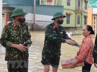 Đại diện lãnh đạo Bộ Chỉ huy Quân sự tỉnh Nghệ An trao hỗ trợ nhu yếu phẩm cho người dân xã Quỳnh Lâm, huyện Quỳnh Lưu, tỉnh Nghệ An.