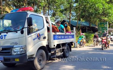 Các công dân ngoại tỉnh hồi hương được lực lượng cảnh sát giao thông, Công an tỉnh Yên Bái giúp chuyên chở phương tiện hỏng và hộ tống dẫn đường qua địa phận tỉnh Yên Bái tại Chốt kiểm dịch số 6, xã Minh Quân, huyện Trấn Yên. Ảnh: Minh Huyền