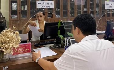 Cán bộ Sở Xây dựng giải quyết thủ tục hành chính cho người dân và doanh nghiệp tại Trung tâm Phục vụ hành chính công tỉnh.