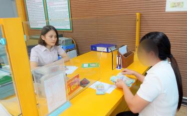 Cán bộ Phòng giao dịch Ngân hàng Chính sách xã hội huyện Lục Yên làm thủ tục, giải ngân vốn cho người chấp hành xong án phạt tù.