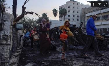 Người dân Palestine bước qua đống đổ nát của bệnh viện Al-Ahli, miền trung Dải Gaza, ngày 18/10.
