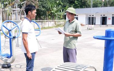 Ông Ngô Văn Lượng (bên phải) báo cáo việc triển khai các phần việc xây dựng nông thôn mới của thôn với lãnh đạo Ủy ban Mặt trận Tổ quốc xã Phú thịnh.