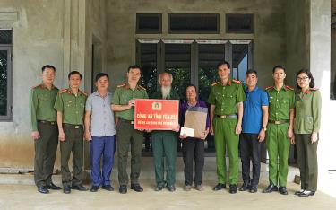 Đại tá Đinh Xuân Thiệp – Phó Giám đốc Công an tỉnh (đứng giữa) trao hỗ trợ xây nhà tình nghĩa cho gia đình có hoàn cảnh đặc biệt khó khăn tại địa bàn xã Nghĩa Tâm, huyện Văn Chấn.